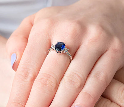 Diamond Style London - Oval cut blue ring with clear side stones in rhodi (Item code: Bluering6)